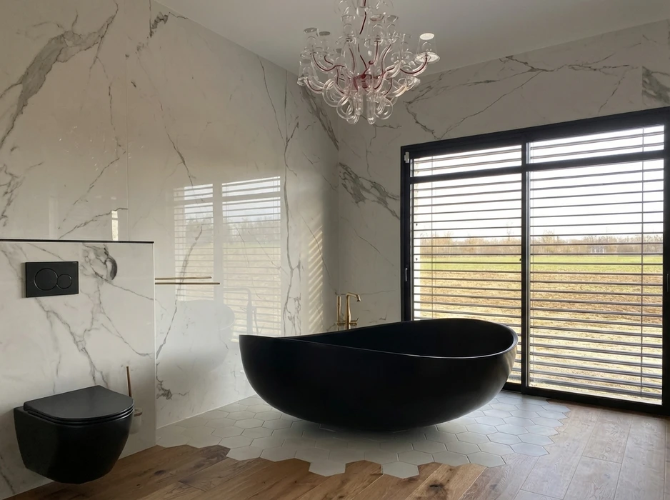 Salle de bain luxueuse avec baignoire îlot noire mate ovale, robinetterie dorée laiton brossé