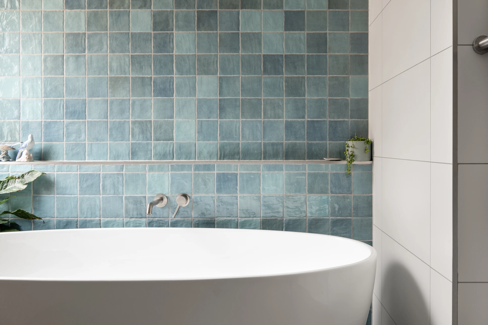 Salle de bains moderne avec baignoire blanche, lavabo rond suspendu et robinetterie chromée