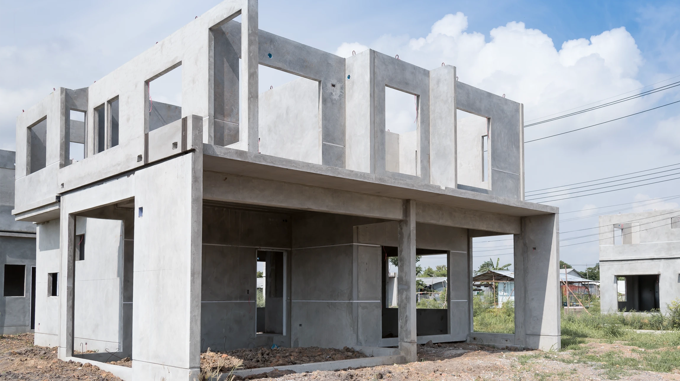 La structure en bois encadrant le chantier contre un vaste ciel nuageux au soleil brillant derrière