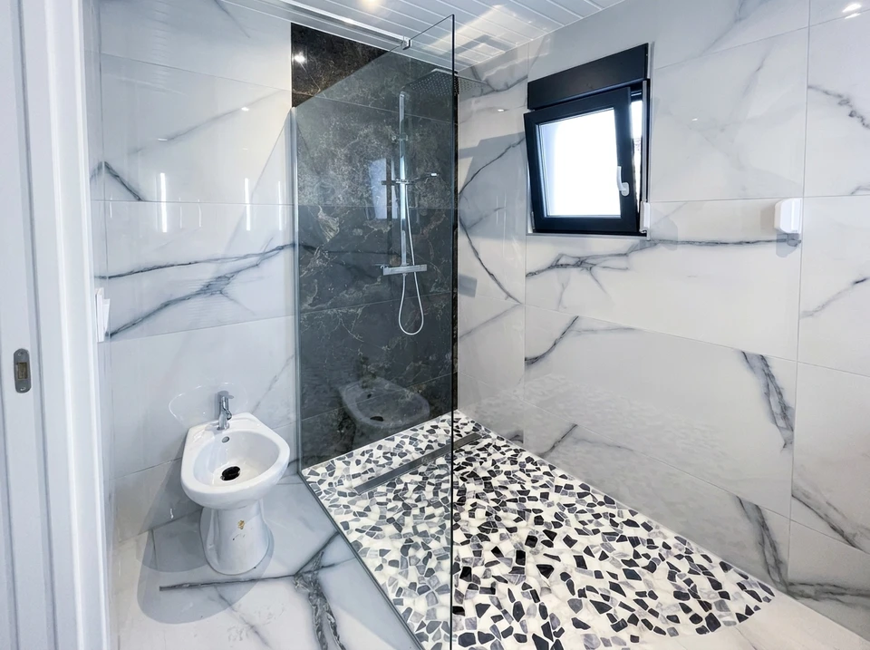 Salle de bain moderne avec double vasque à poser sur meuble laqué blanc et plan en bois massif