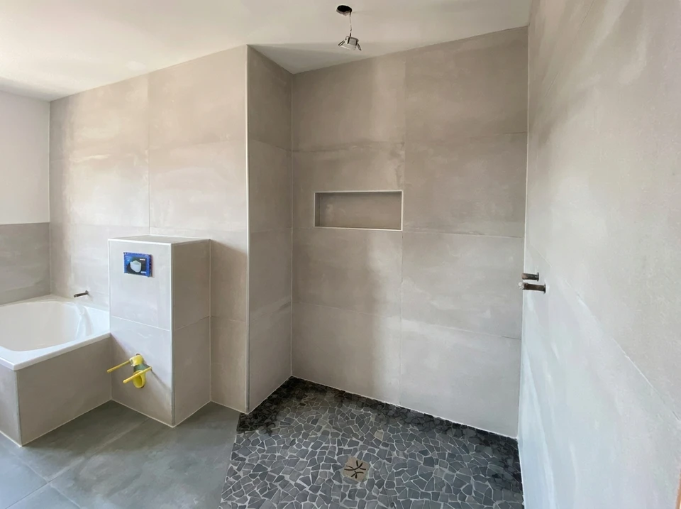 Salle de bain design industriel avec vasque à poser rectangulaire noire en pierre/béton, robinetterie dorée laiton brossé, sur plan de travail en chêne massif live-edge