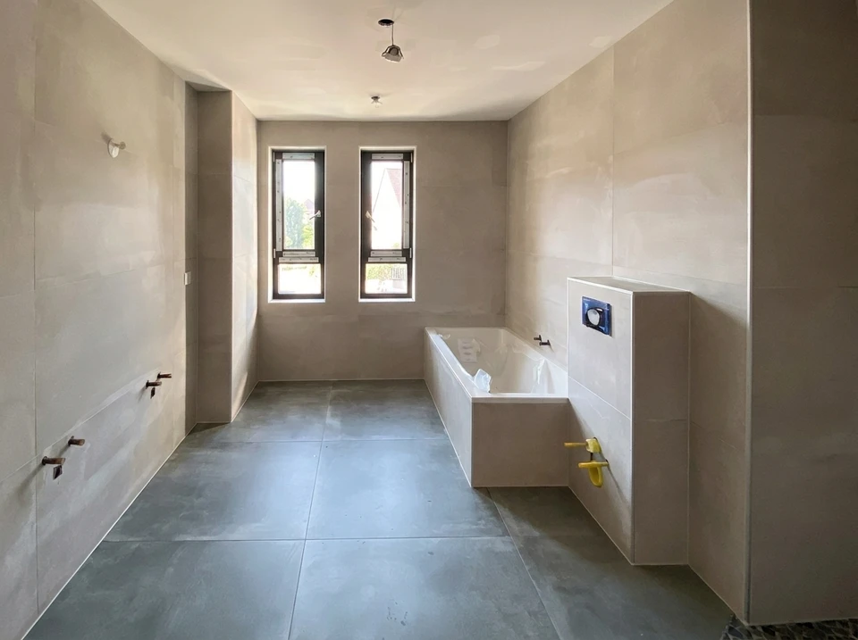 Salle de bain design industriel avec vasque à poser rectangulaire noire en pierre/béton, robinetterie dorée laiton brossé, sur plan de travail en chêne massif live-edge