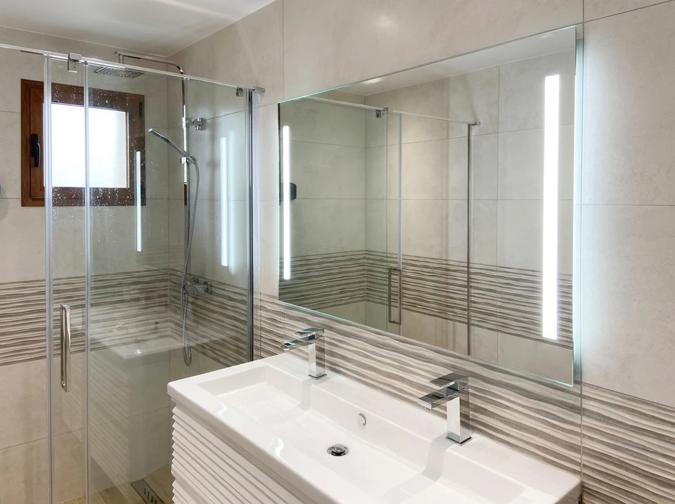 Salle de bain design industriel avec vasque à poser rectangulaire noire en pierre/béton, robinetterie dorée laiton brossé, sur plan de travail en chêne massif live-edge