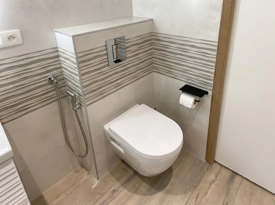 Salle de bain design industriel avec vasque à poser rectangulaire noire en pierre/béton, robinetterie dorée laiton brossé, sur plan de travail en chêne massif live-edge