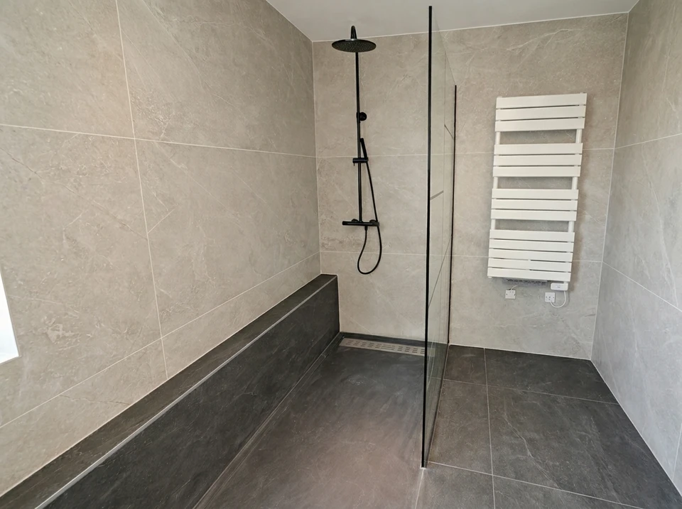 Salle de bain design industriel avec vasque à poser rectangulaire noire en pierre/béton, robinetterie dorée laiton brossé, sur plan de travail en chêne massif live-edge